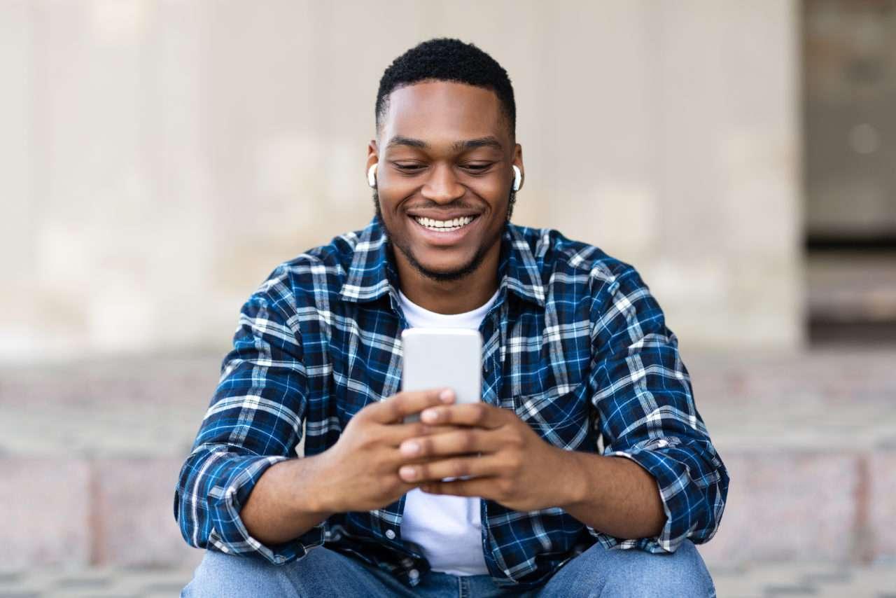 Man Smiling while Browsing his Phone