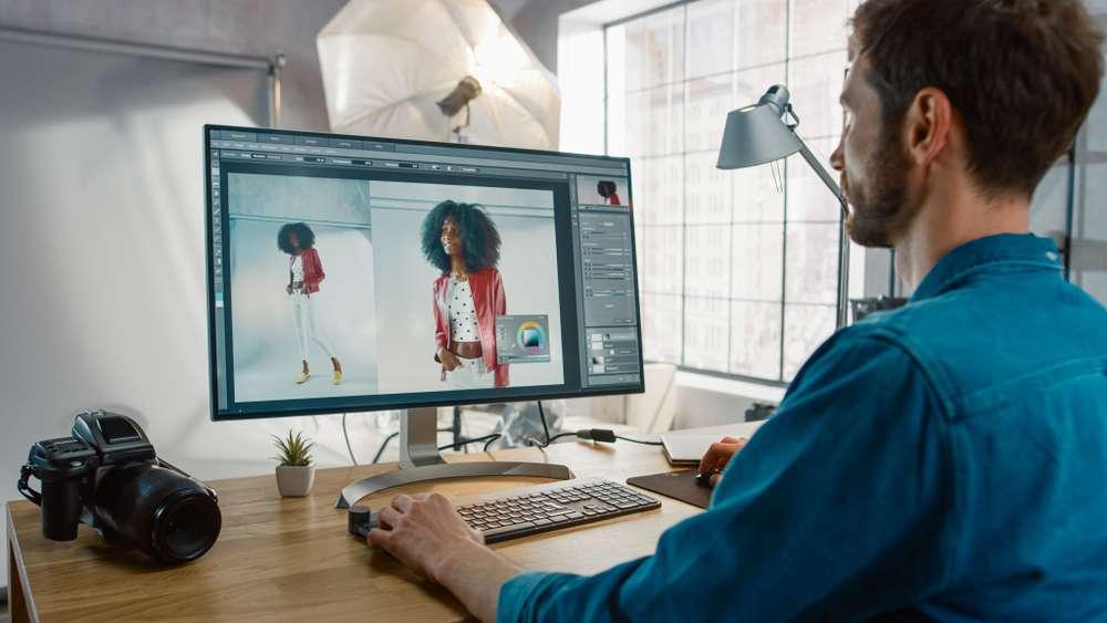 Professional Photographer Sitting At His Desk Using Adobe