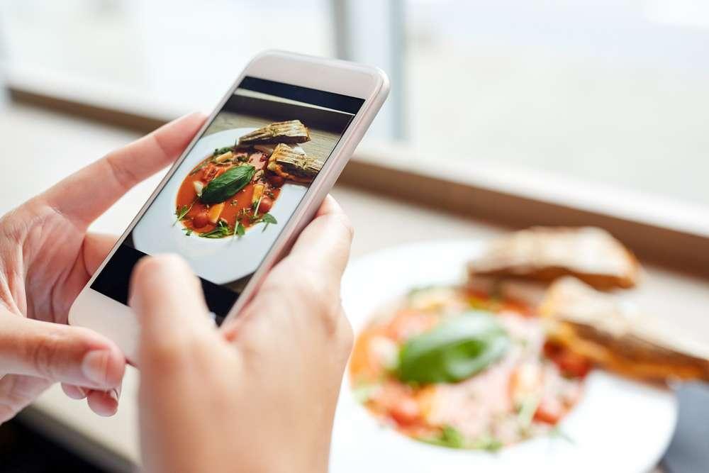 a person taking a picture of food with their iPhone