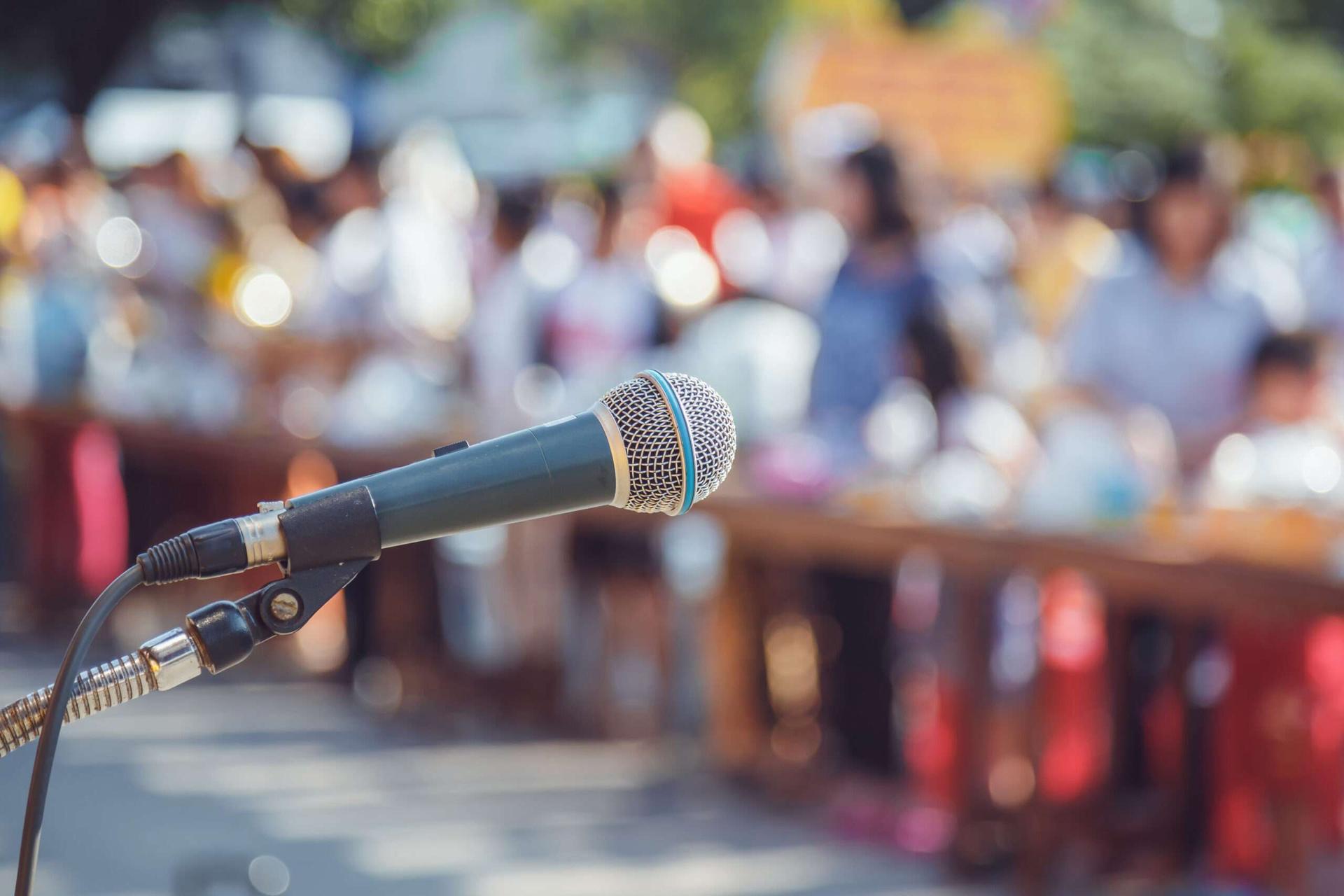image of a microphone in front of a crowd