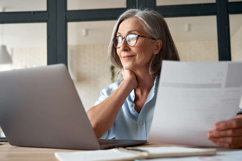 Smiling Mature Businesswoman Using Laptop