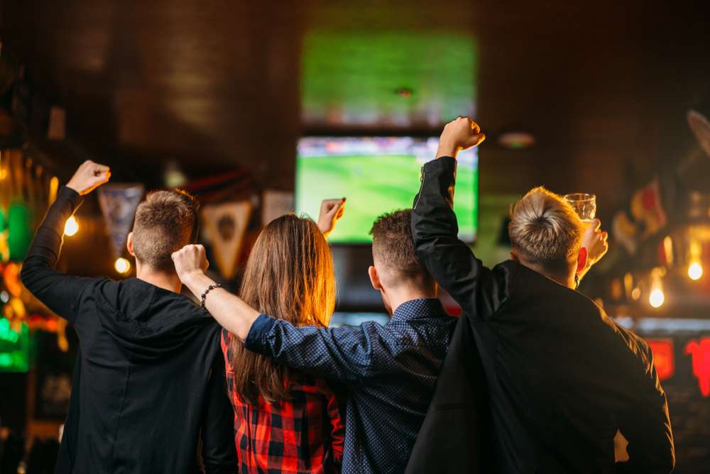 Friends watch the Super Bowl live in a public space