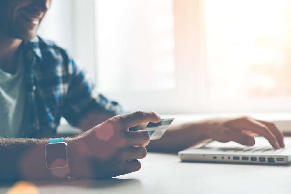 An Online Shopper with Credit Card and Facing a Laptop