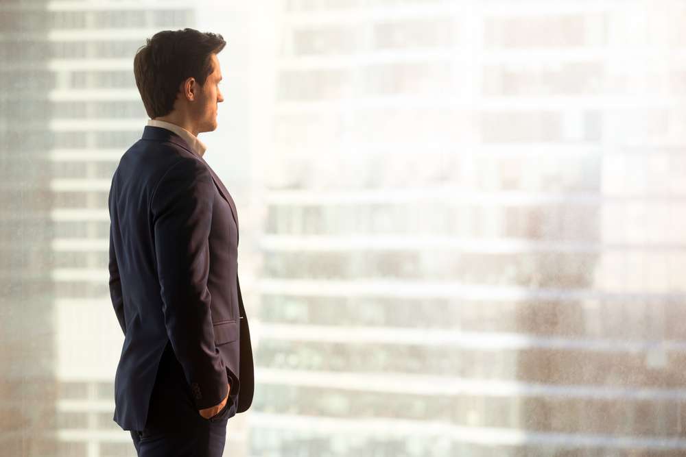 Business Man Standing and Facing the City