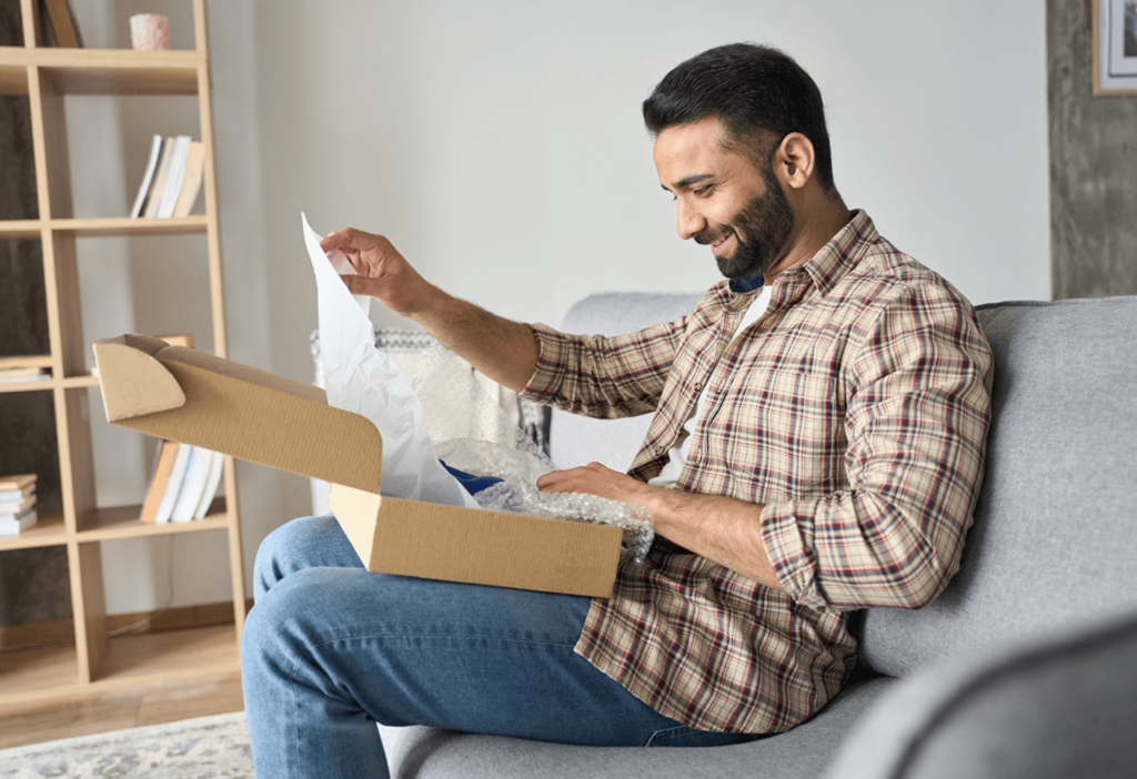 a person sitting on a couch opening a package