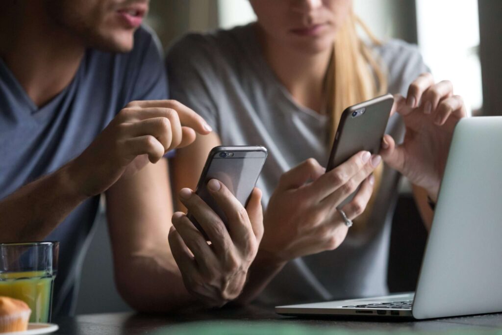 Two people looking at and interacting with their phones